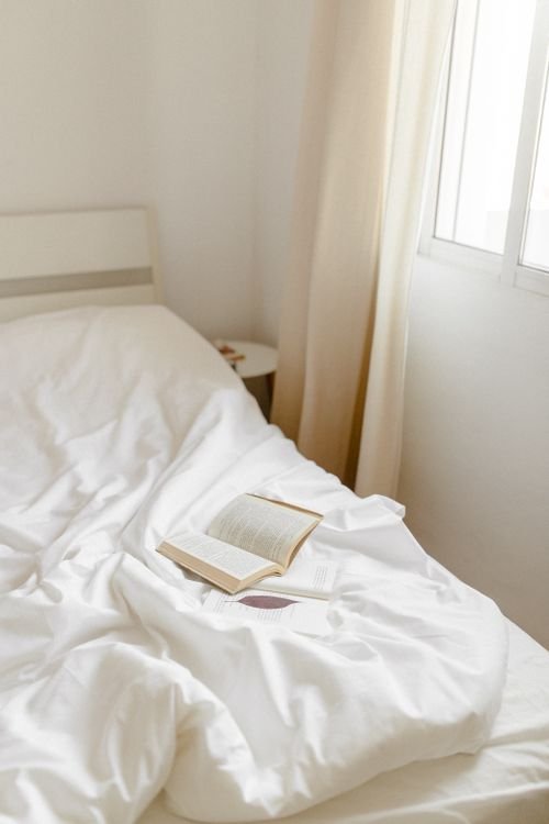 Open book on a calm bed in soft sunlight for a bedtime routine for better sleep